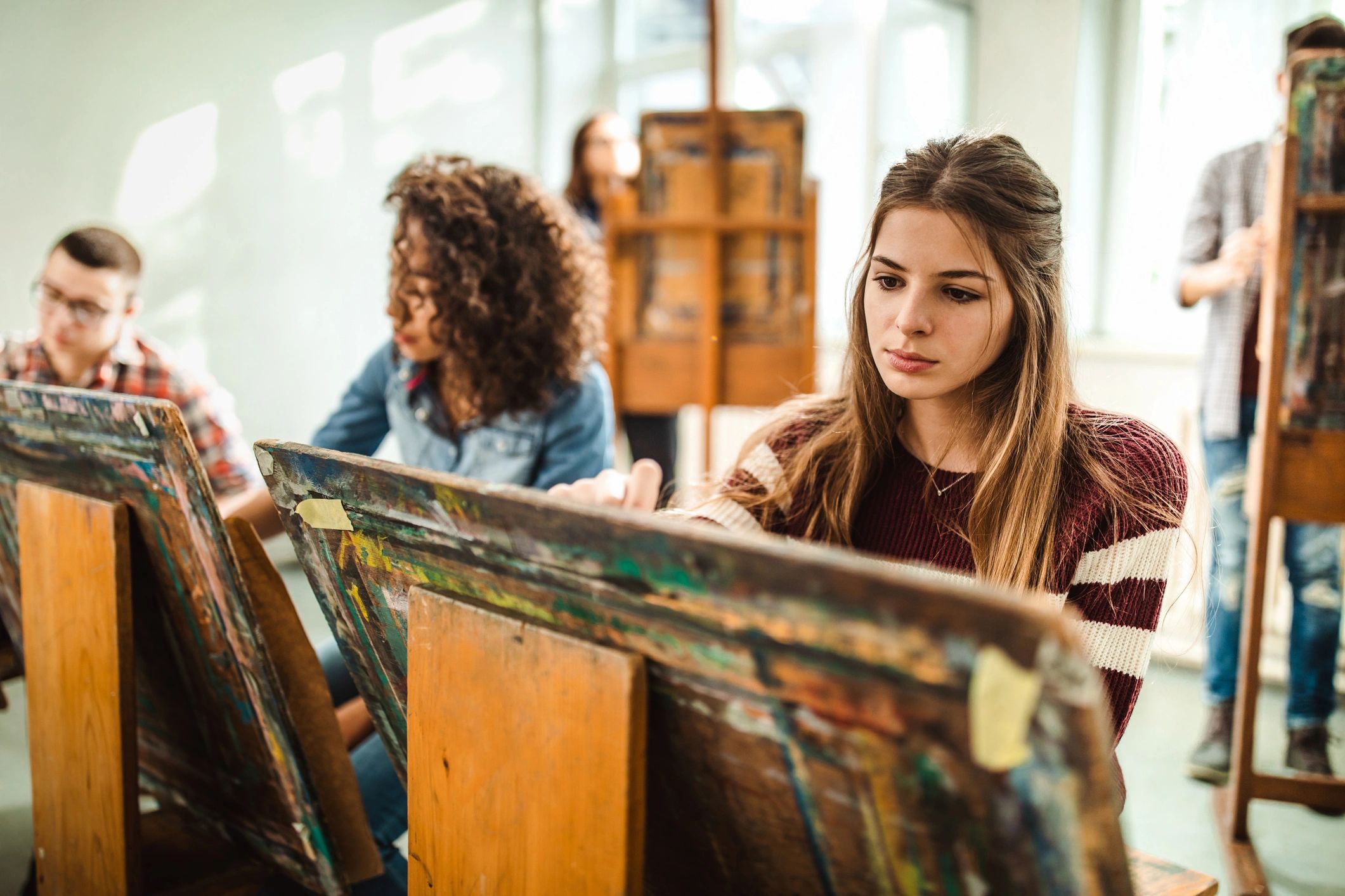 Teens working together on paintings in an art studio