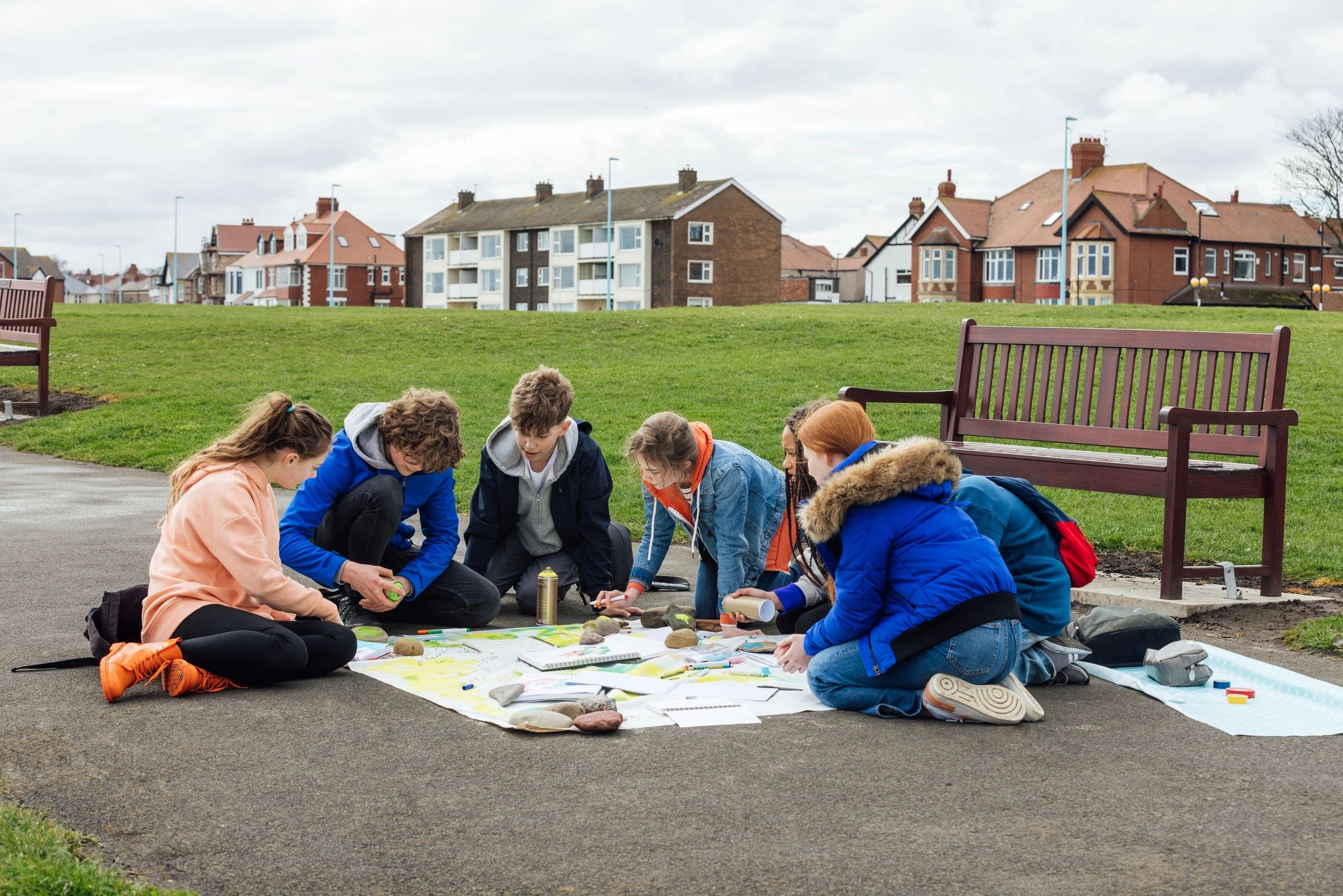 Children painting together at a table outdoors